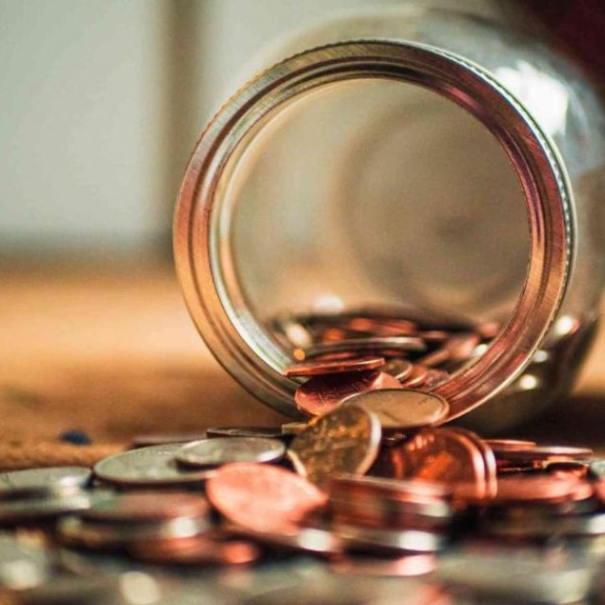 Jar tipped on its side with coins pouring out