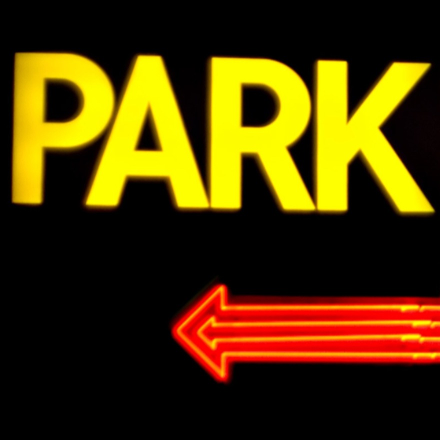 Yellow PARK text with a red arrow pointing left on a black background