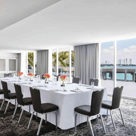 a meeting space set up as a boardroom with floor to ceiling windows and a view of the bay