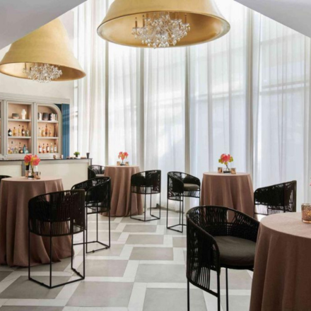 a beautiful ballroom space with tall ceilings and golden chandeliers, set up for a cocktail reception