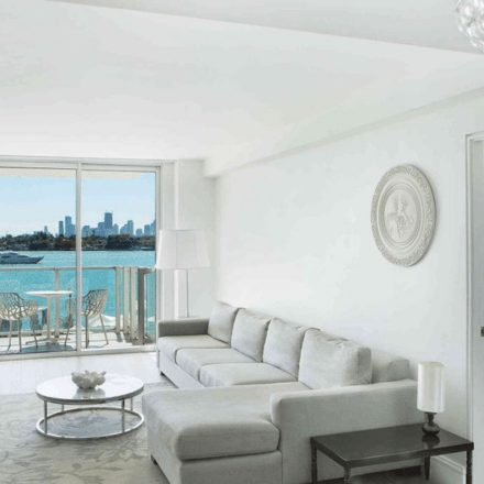 a large suite area with a grey sectional couch and views of the bay