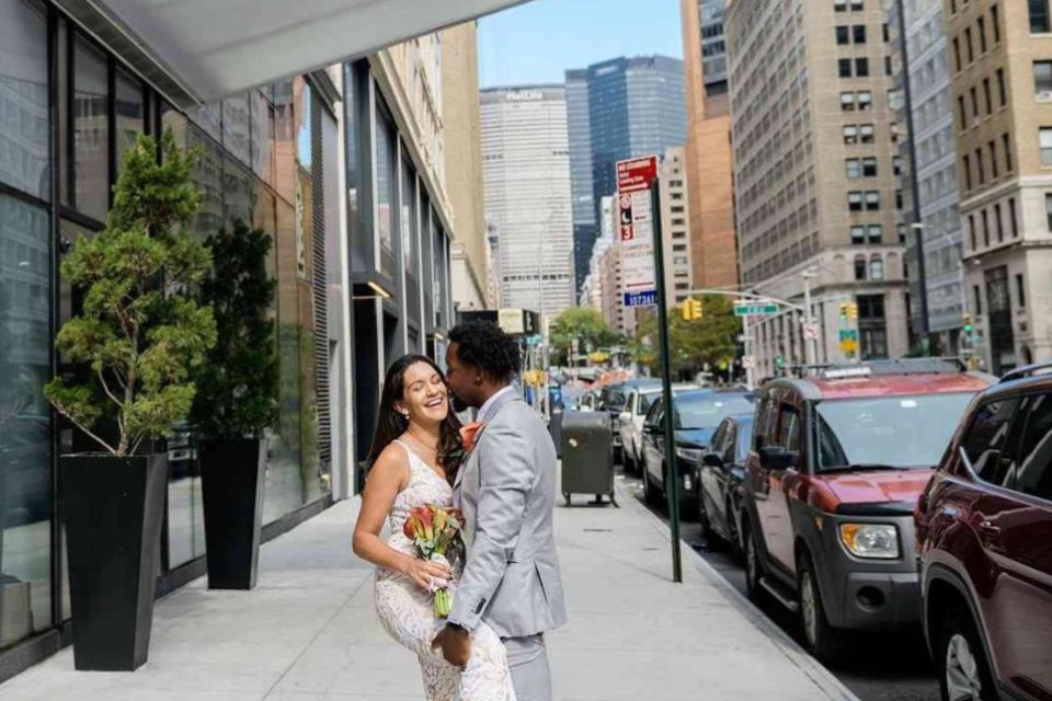 Bride and groom embrace on a city street