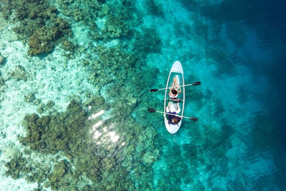 Kayak with two people in it floating on a bright blue sea