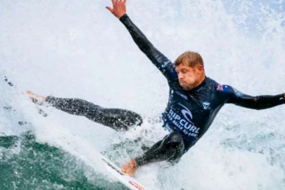 Man surfing a wave in a black wetsuit