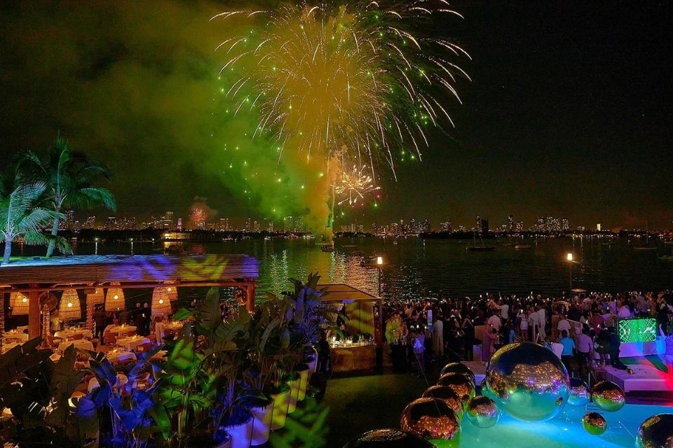 fireworks go off in a night sky overlooking the ocean